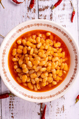 Dry bean meal. Dry bean dish in plate on white wooden background. Local name kuru fasulye. Top view