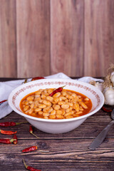 Dry bean meal. Dry bean dish in plate on wooden floor. Local name kuru fasulye