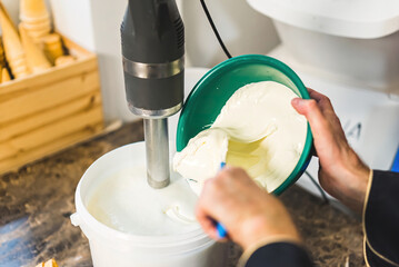 Close shot of man hands mixing ice cream ingredients with a blender. High quality photo