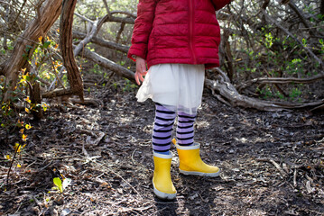 Anonymous Child Exploring the Woods with Rubber Boots and Tutu Dress