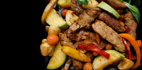 Tender veal with roasted vegetables on black skillet