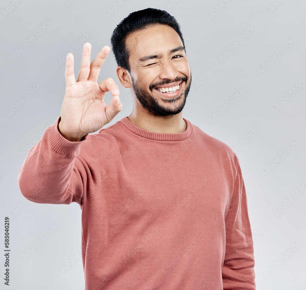 Poster perfect, winking and portrait of an asian man with a hand gesture isolated on a white background in 