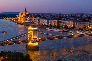 Fototapeta na wymiar Evening view of Danube river with Szechenyi Lanchid bridge and Hungarian Parliament Building in Budapest, Hungary