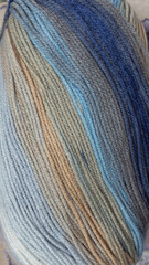 Close up colorful yarn texture background, pastel aqua green turquoise and creamy beige brown strains, coiled in ball skein. Knitting and crochet, home craft work. Winter color combination for styling