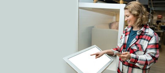 Woman uses the self-service kiosk in the store.