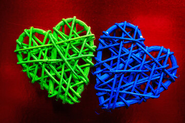 Wooden wicker heart. Rattan work in the shape of a heart. Love concept. Background with selective focus. On colored foil