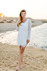 Frau am Strand im Urlaub mit weißem Kleid