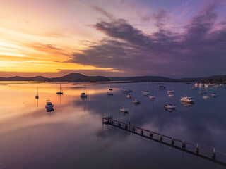 Aerial sunrise waterscape with boats and high cloud