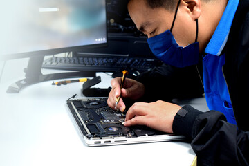 A young man who is a computer technician laptop motherboard repair technician Technician is...