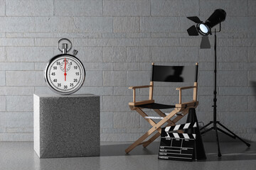 Stopwatch with Blank Screen near Director Chair, Movie Clapper and Spotlight. 3d Rendering