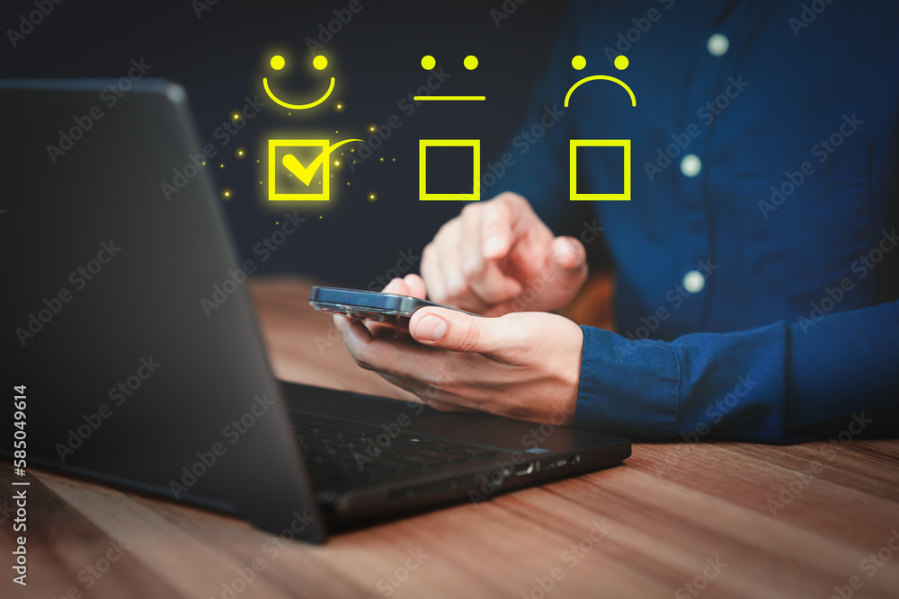 Poster Man hand using a mobile phone with popup smile face icon for feedback review satisfaction service and testimonial. Customer service experience assessment and business satisfaction survey.