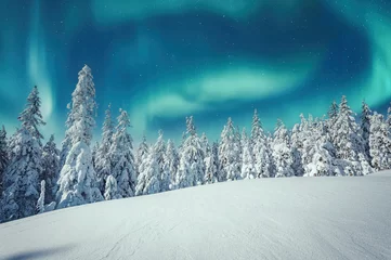 Fototapete Nordeuropa Aurora borealis over the frosty forest. Green northern lights above mountains. Night nature landscape with polar lights. Night winter landscape with aurora. Creative image. winter holiday concept.