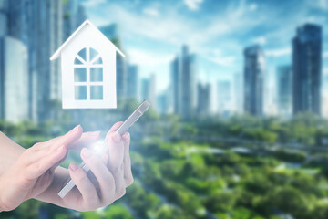 real estate online, hand with a phone on the background of a modern green eco city