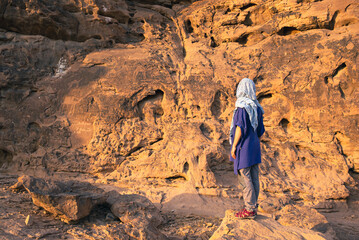 A western tourist views the prehistoric rock carvings at Jubbah, a UNESCO World Heritage Site in Saudi Arabia