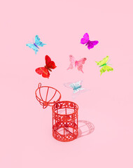 Open bird cage and colorful butterflies, creative aesthetic romantic spring inspired layout against...