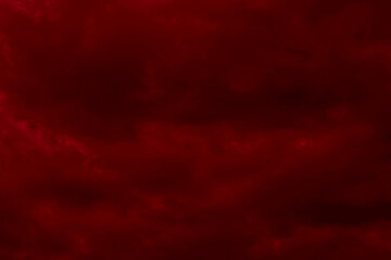 Red cloudy night sky background. Blurred photo of dark red sky. Photo can be used for the concept of galaxy space New Year, Christmas and Halloween backgrounds.