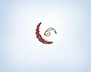 Assorted types of ripped dates and beads arranged in moon shape. The concept of the Islamic month of Ramadan.