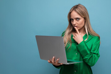 business lady freelancer thinking about work holding a laptop in her hands on a blue bright background