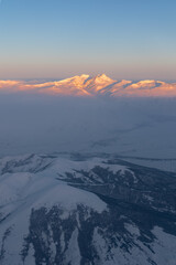 Fototapeta na wymiar Aerial high altitude view of Mount Aragats highest mountain in Armenia lit by rising sun, Caucasus