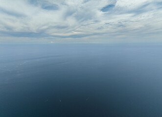 Aerial view of blue ocean with waves and blue sky with cloud, aerial view. Water cloud horizon background.