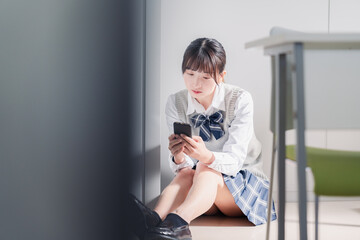 スマホを見ながら落ち込む女子高生