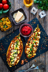 Roasted aubergine stuffed with minced meat and cheese  on wooden table