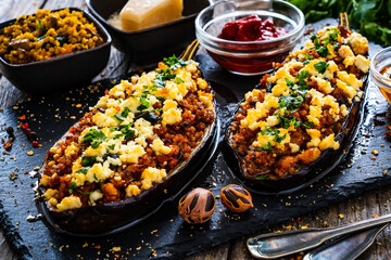 Roasted aubergine stuffed with minced meat and cheese  on wooden table