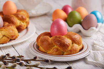 Traditional Easter bun bread in a shape of wreath made from yeast dough decorated with colored egg....