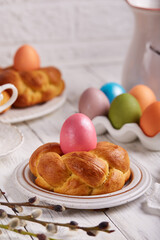 Traditional Easter bun bread in a shape of wreath made from yeast dough decorated with colored egg. Traditional Easter symbols and food. Easter baking