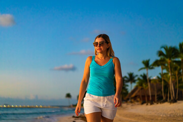 Fototapeta na wymiar Beach holiday - beautiful woman walking, running on sunny, tropical beach 