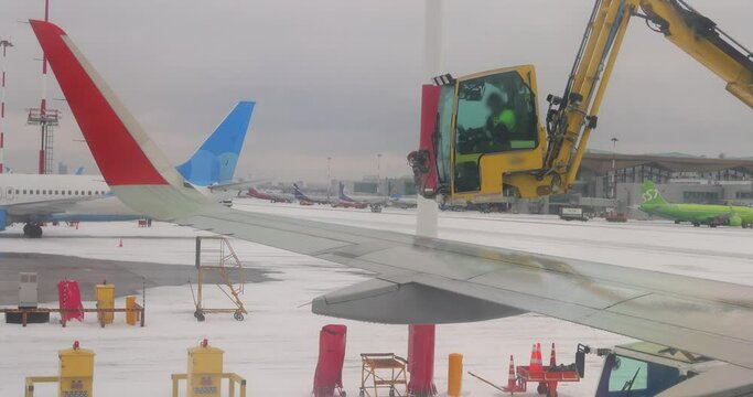 De icing of airplane before flight. Anti-icing is the application of chemicals that not only deice but also remain on a surface and continue to delay the reformation of ice
