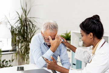 Obraz premium Depressed male senior adult in ambulance with afro american doctor. Doctor support and comforting her patient with sympathy