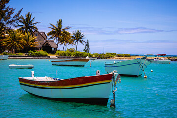 Fototapeta na wymiar boat on the beach of mauritius with blue water