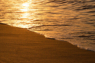 Sun reflecting off waves and sand along a beach in Florida