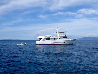 Motor yacht. Cruise ship. Safari Dive Boat. Luxury white motor yacht and small inflatable motorboat on the open sea.