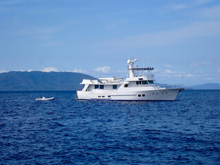 Motor yacht. Cruise ship. Safari Dive Boat. Luxury white motor yacht and small inflatable motorboat on the open sea.