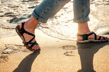 Close up of woman feet walking  on seaside . Vacation, travel and freedom concept. People relaxing in summer.