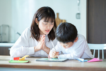 部屋で遊ぶ子供と褒める母親