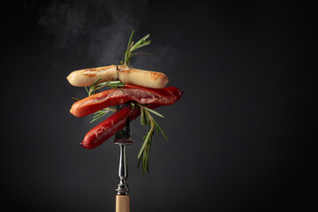 Sausages with rosemary on a fork.