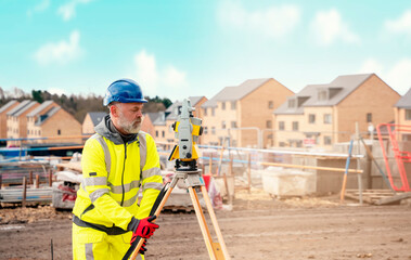 Surveyor builder site engineer with theodolite total station at construction site outdoors during...