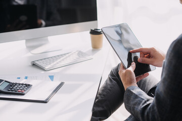 Attractive smiling young asian business woman work at home office, Asian woman working on laptop computer holding tablet.