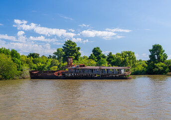 Fototapeta premium Abandoned and rotting tour or cruise boat on banks of Parana delta near Tigre Argentina