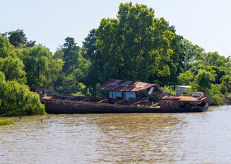 Abandoned and rotting tour or cruise boat on banks of Parana delta near Tigre Argentina