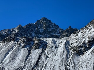 First snow on the rocky mountain peak Schwarzhorn (3147 m) in the Albula Alps and above the Swiss mountain road pass Fluela (Fl&uuml;elapass), Davos - Canton of Grisons, Switzerland (Schweiz)