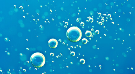 Underwater background of clear blue water with oxygen bubbles closeup