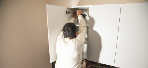 Worker assembling of new kitchen furniture.