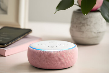 Amazon echo speaker pink on a table next to a plant