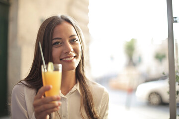 young woman drinks a juice in a bar