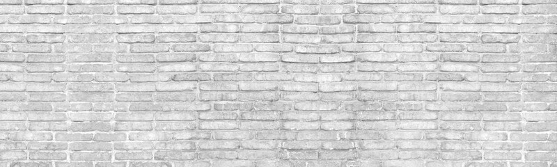 Old shabby distressed white brick wall wide texture. Aged rough whitewashed masonry. Light gray grunge background