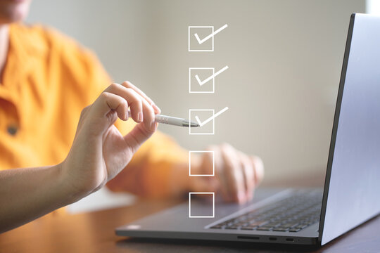 Business performance checklist concept, businessman using laptop doing online checklist survey, filling out digital form checklist.